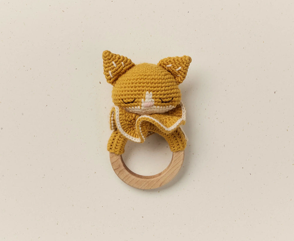 Crocheted cat rattle on a wooden ring with a plain background