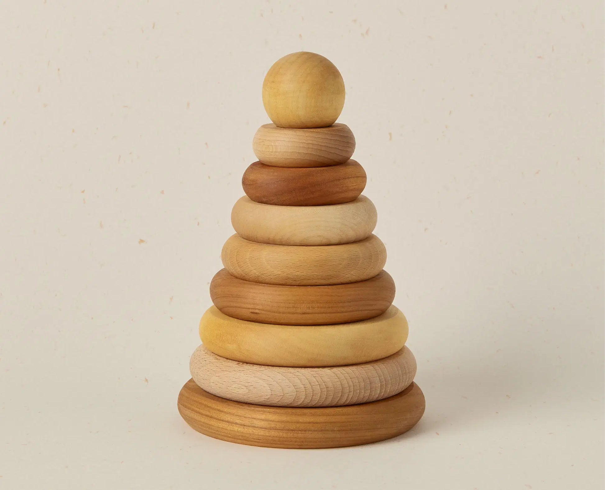Wooden stacking ring toy on a beige background
