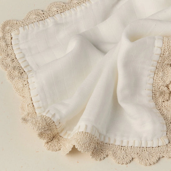 White fabric with beige lace trim on a light background