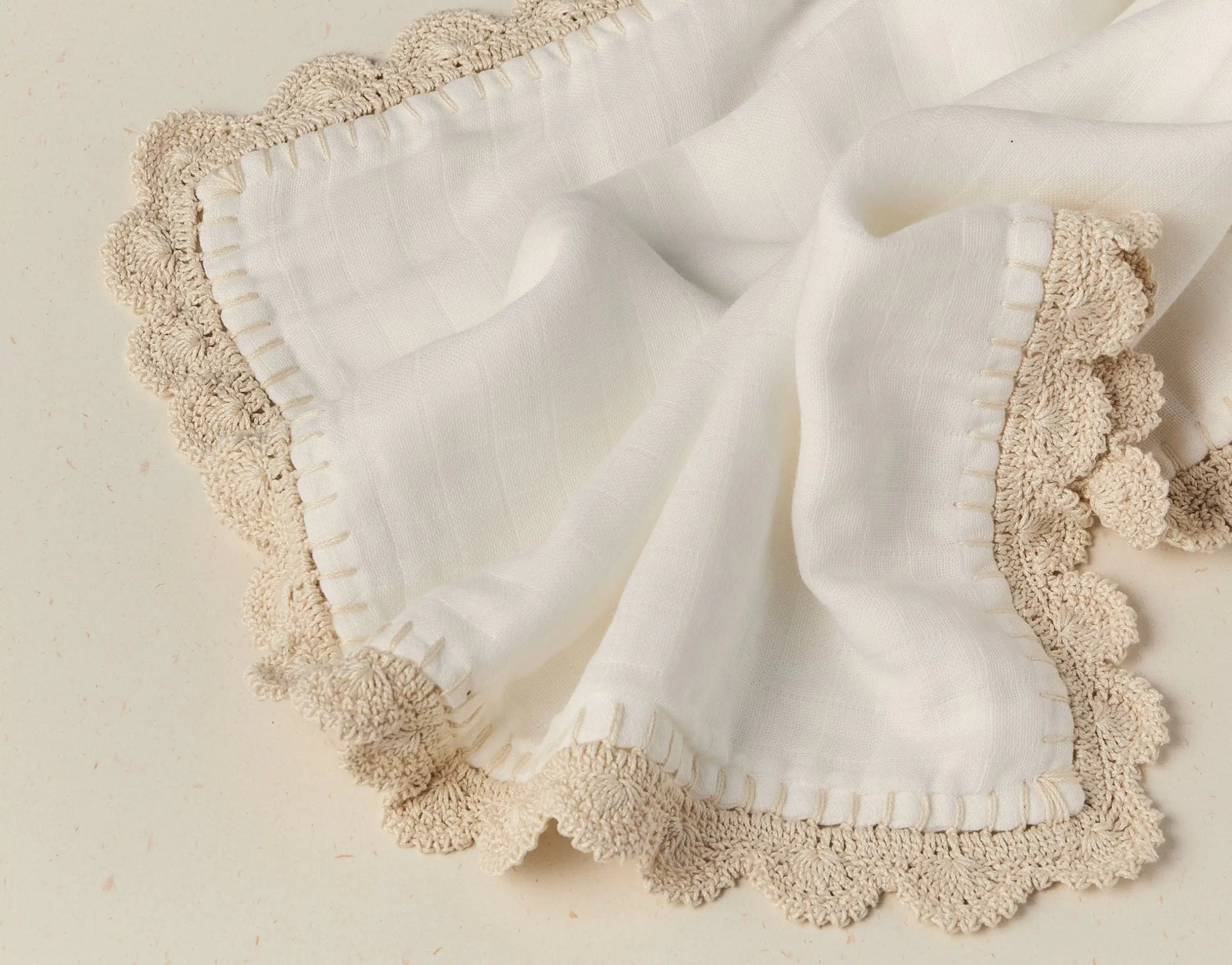 White fabric with beige lace trim on a light background