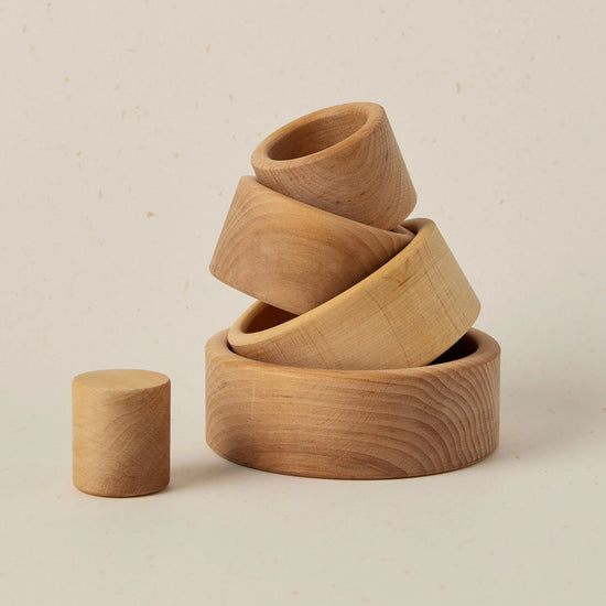 Set of wooden bowls stacked on a beige background