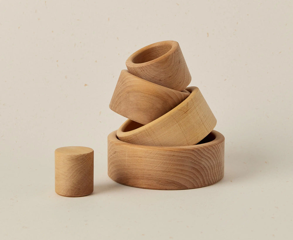 Set of wooden bowls stacked on a beige background