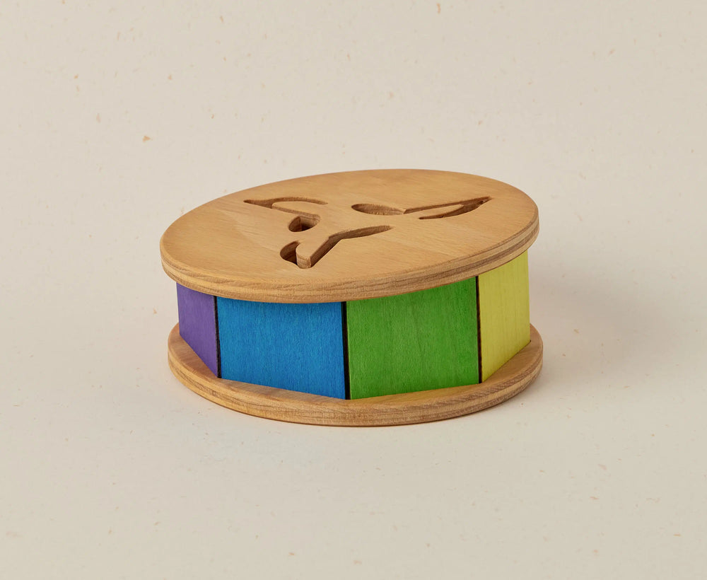 Wooden toy with colorful cylindrical sections on a beige background