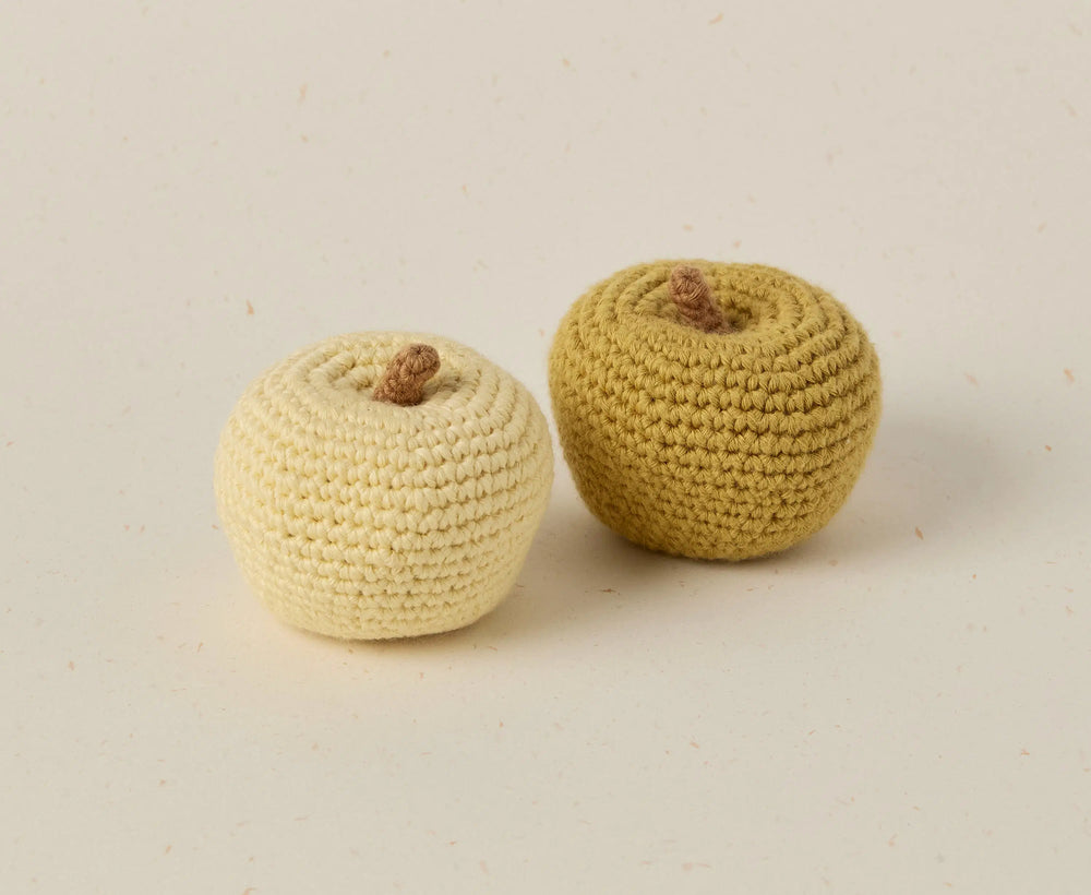 Two crocheted apples on a beige background