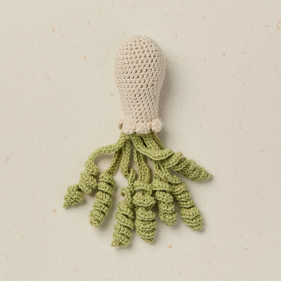 Crocheted squid toy on a beige background
