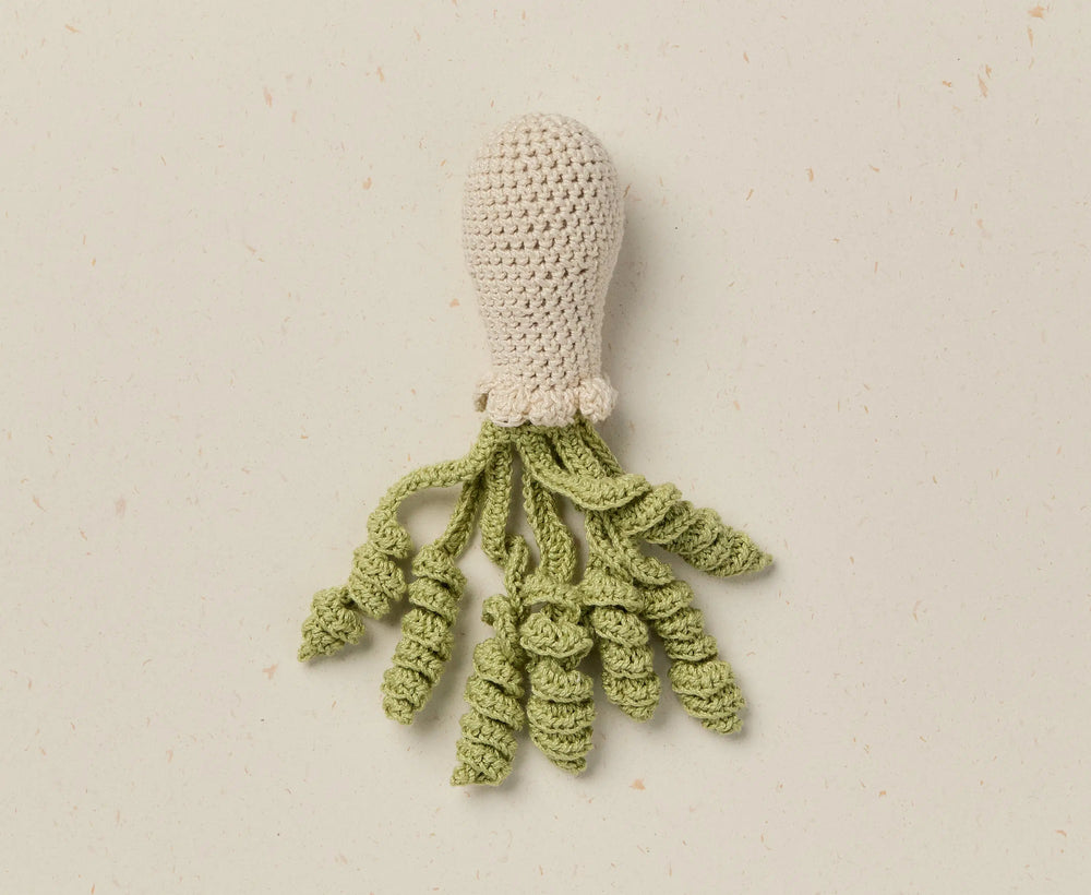 Crocheted squid toy on a beige background
