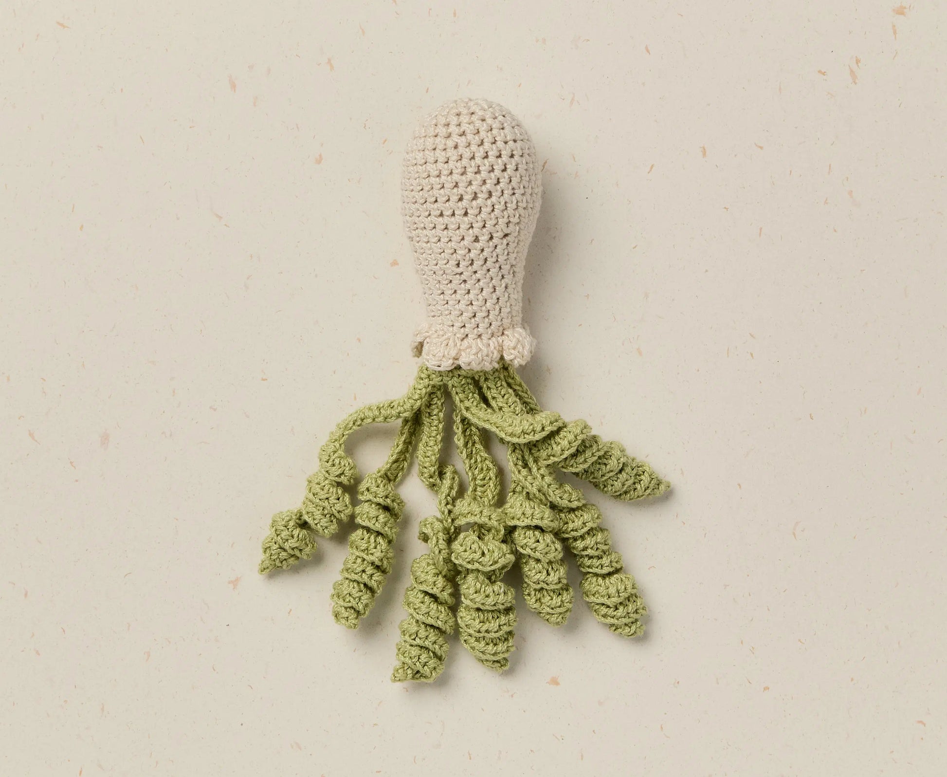 Crocheted squid toy on a beige background