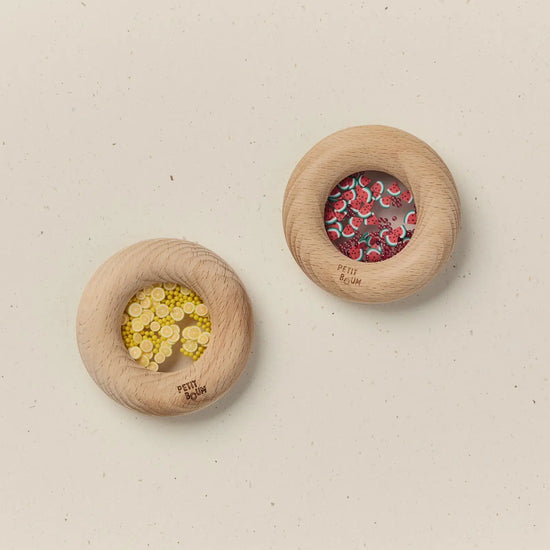 Two wooden donuts with decorative elements on a beige background
