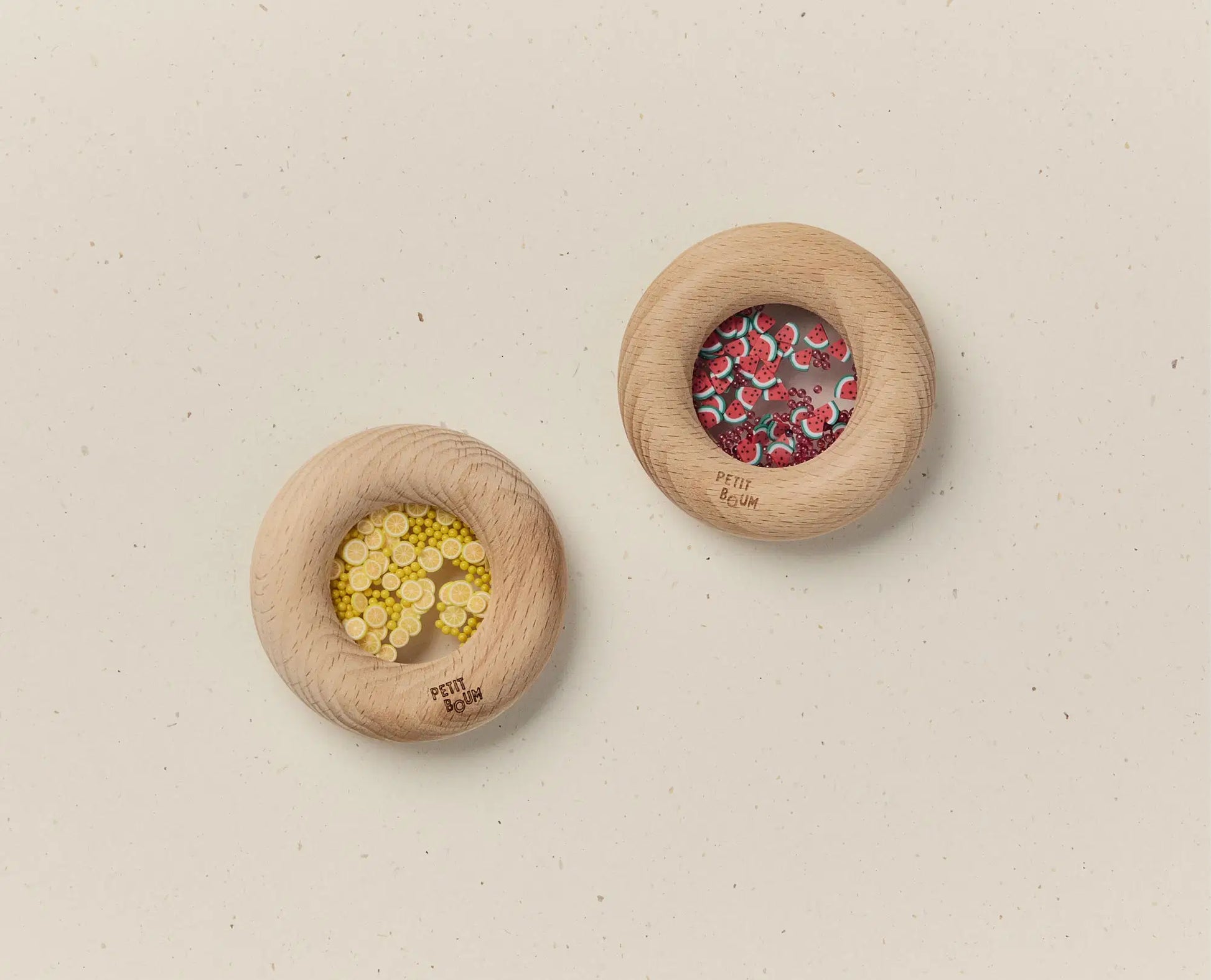 Two wooden donuts with decorative elements on a beige background