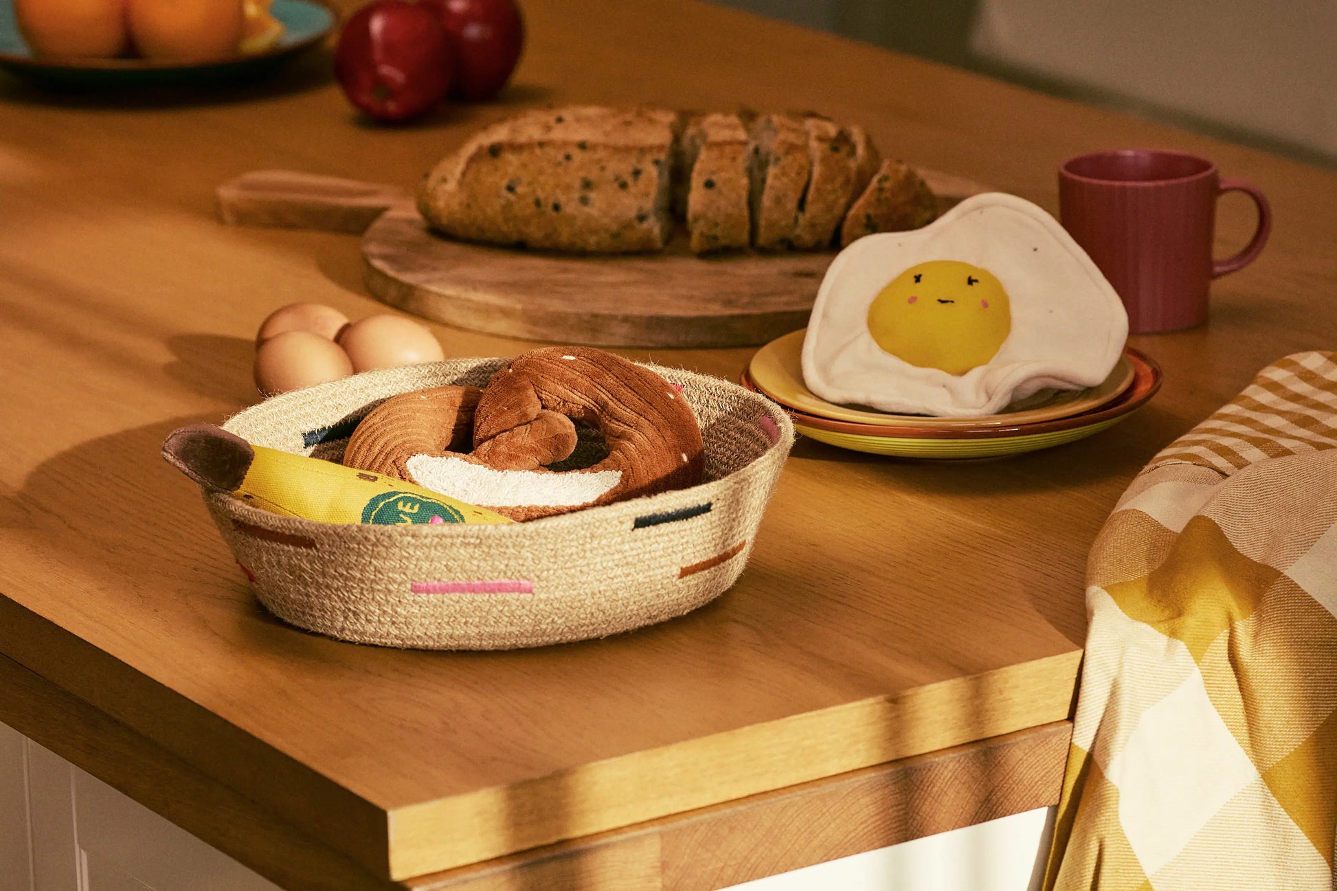 Wooden table with bread, eggs, and a smiley face egg on a plate.