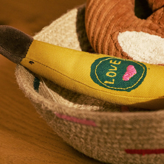Close-up of a plush toy with a heart and 'LOVE' patch on a wooden surface