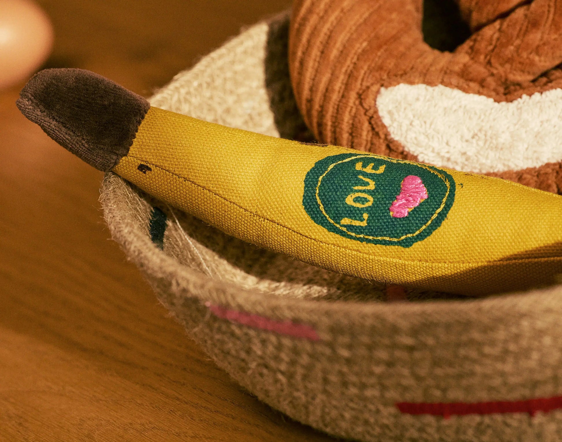 Close-up of a plush toy with a heart and 'LOVE' patch on a wooden surface