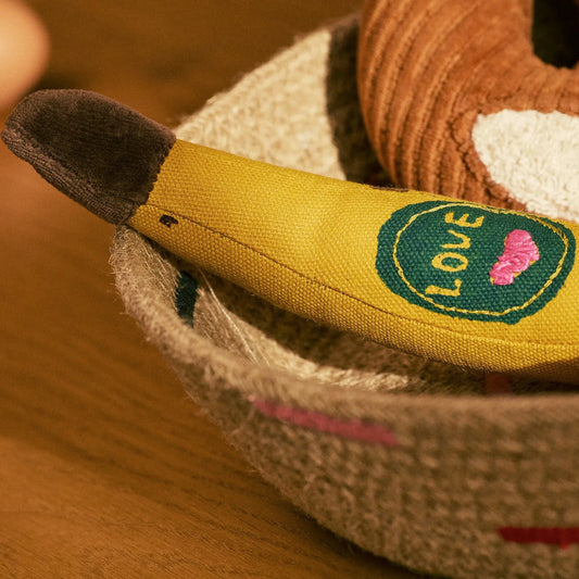 Close-up of a plush toy with a heart and 'LOVE' patch on a wooden surface